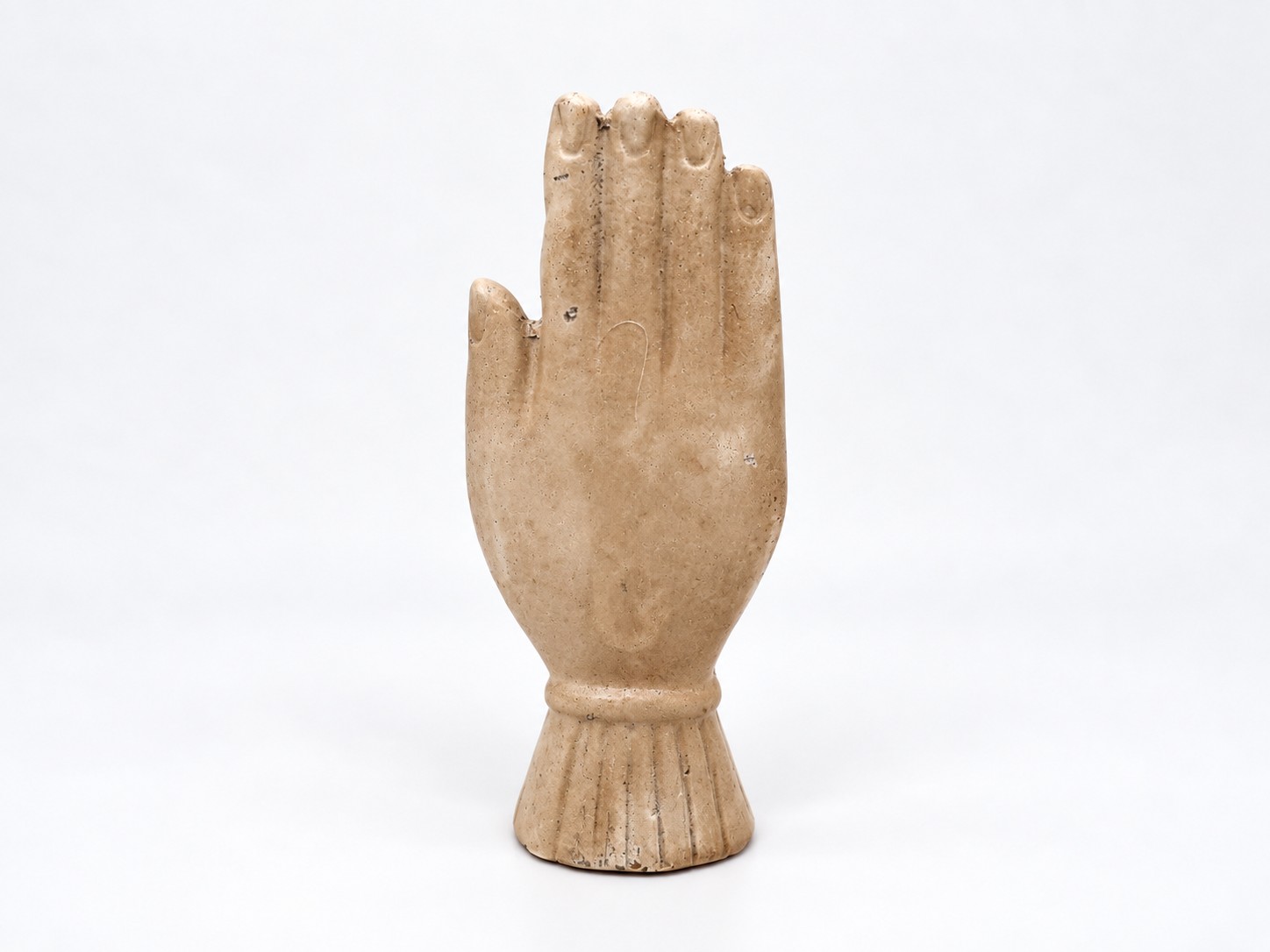 Achterkant van beige keramieken hand met hart