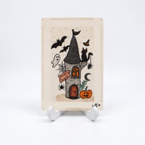 Handbeschilderde Halloweenkaart Het spookt in de toren van By Mieke met spooktoren, zwarte kat, vleermuizen en pompoen.